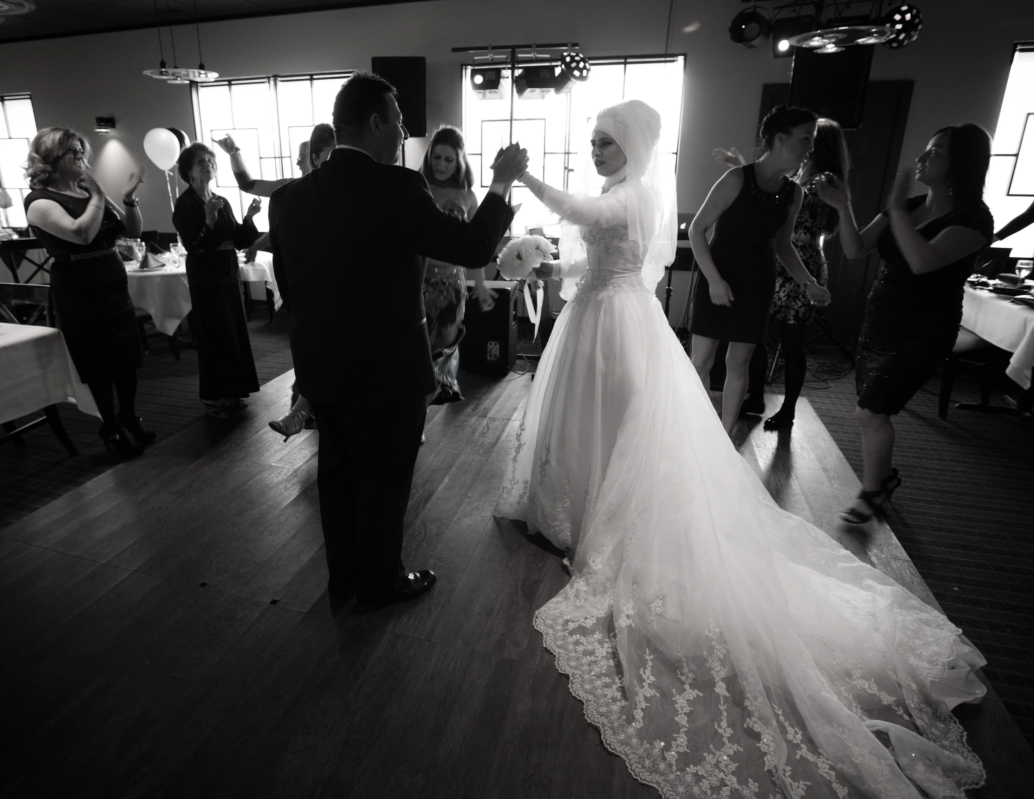 A first dance in black and white, the bride's train sweeping across the floor